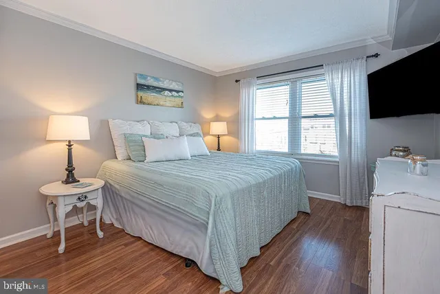 a spacious bedroom with a bed and a flat screen tv