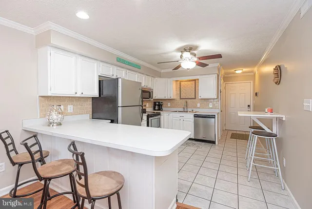 a kitchen with a dining table chairs and refrigerator