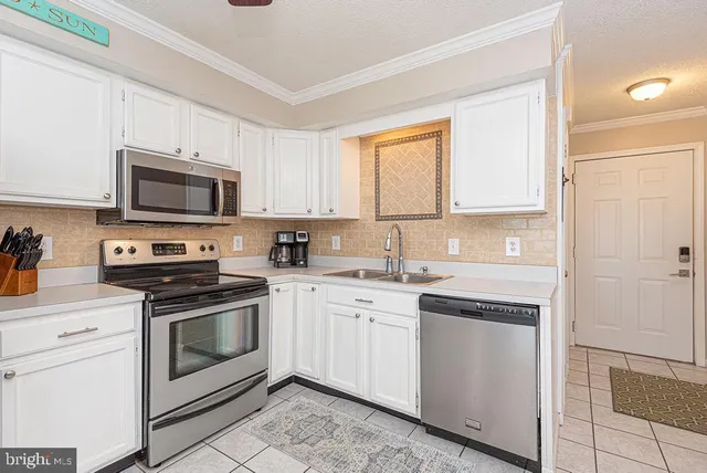 a kitchen with white cabinets appliances and a sink