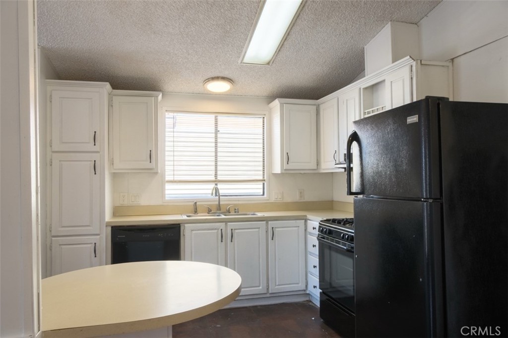 432 South Harbor Boulevard, Unit 7 Santa Ana, CA 92704 - Photo 5 of 35 a kitchen with stainless steel appliances a refrigerator a sink a stove a table and chairs
