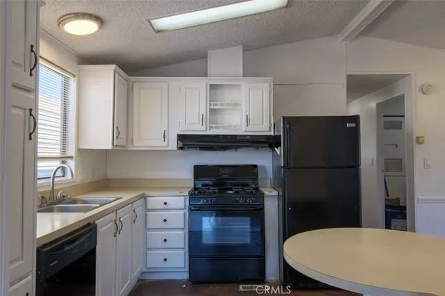 a view of a kitchen with a sink and dishwasher with wooden floor
