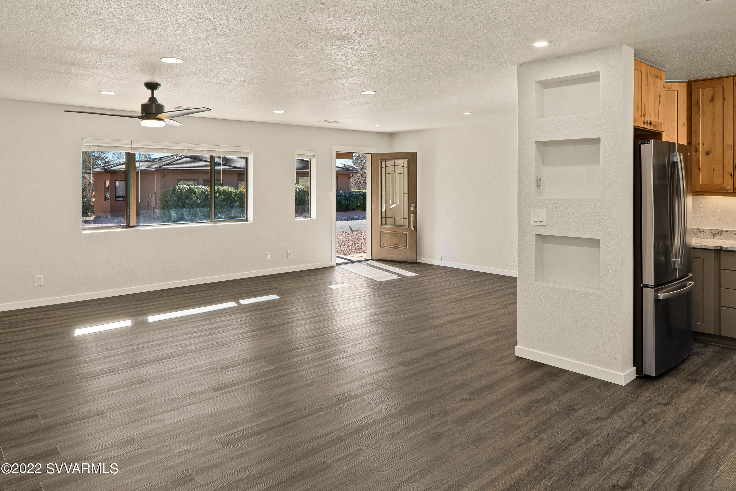 2380 Buckboard Road Sedona, AZ 86336 - Photo 6 of 25 an empty room with wooden floor a ceiling fan and windows