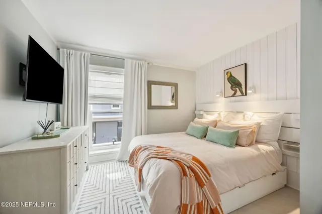 a bedroom with a bed and a flat screen tv