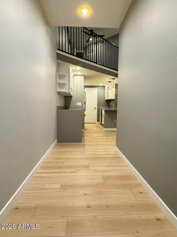 a view of a hallway with wooden floor and staircase