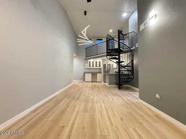 a view of a room with a ceiling fan and hardwood floor