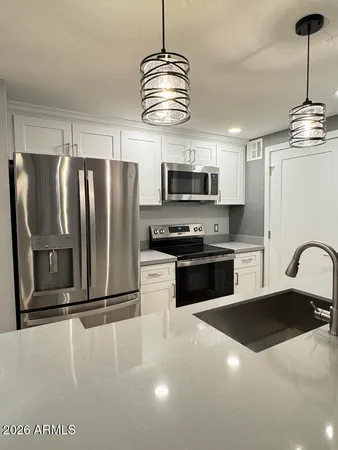 a kitchen with stainless steel appliances a refrigerator and a counter top space