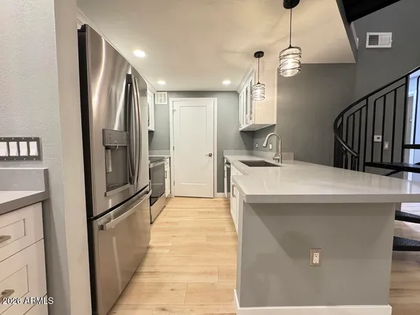 a kitchen with stainless steel appliances a refrigerator sink and microwave