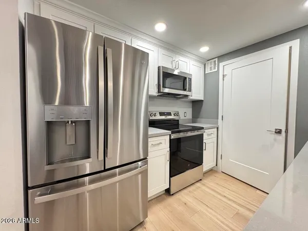 a kitchen with white cabinets a sink and dishwasher