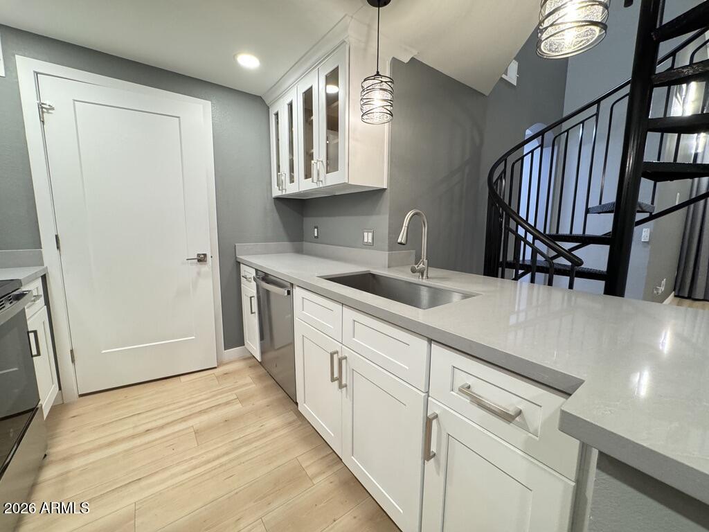 1701 East Colter Street, Unit 431 Phoenix, AZ 85016 - Photo 6 of 23 a kitchen with white cabinets a sink and dishwasher