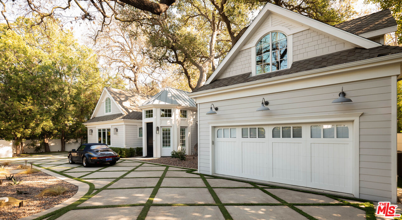 a view of a white house with large windows and a tree