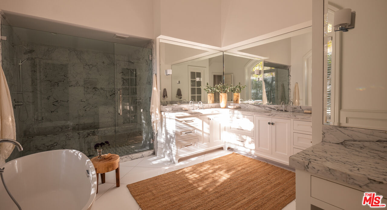 17204 Rancho Street Encino, CA 91316 - Photo 11 of 30 a bathroom with a granite countertop sink a toilet and shower