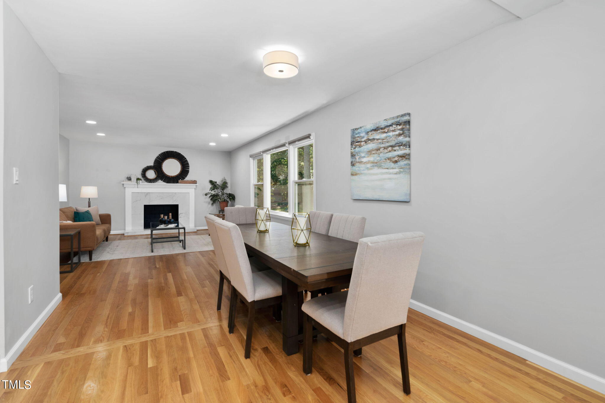 4817 Latimer Road Raleigh, NC 27609 - Photo 11 of 45 a view of a dining room with furniture wooden floor and a fireplace