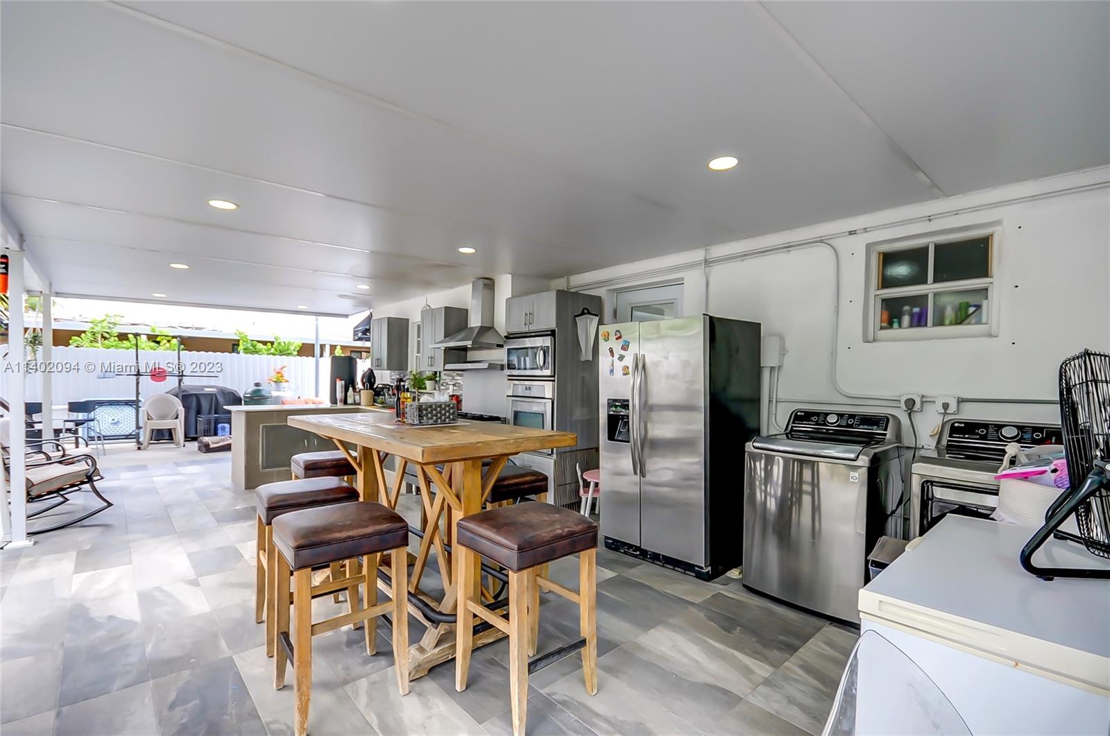 4260 Southwest 99th Avenue Miami, FL 33165 - Photo 19 of 36 a kitchen with stainless steel appliances a dining table chairs stove refrigerator and sink