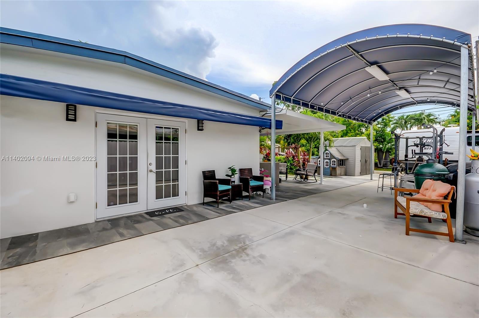 4260 Southwest 99th Avenue Miami, FL 33165 - Photo 29 of 36 a view of a patio with table and chairs under an umbrella