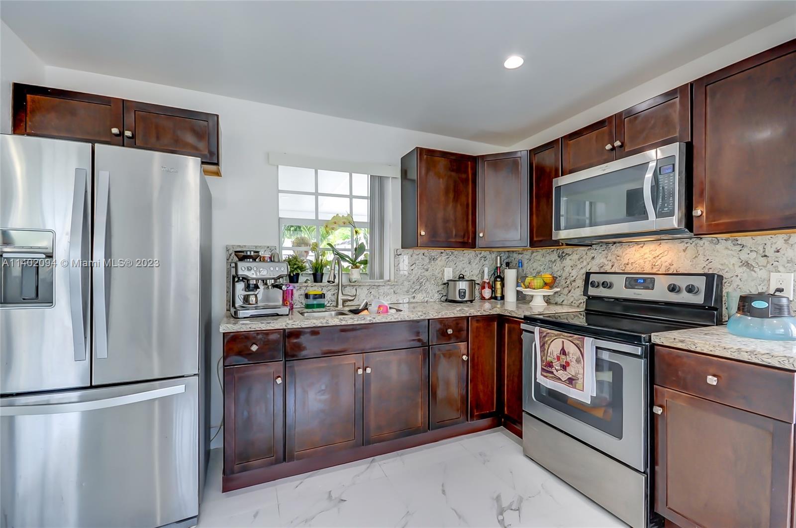 4260 Southwest 99th Avenue Miami, FL 33165 - Photo 3 of 36 a kitchen with stainless steel appliances granite countertop a refrigerator stove a sink dishwasher and microwave