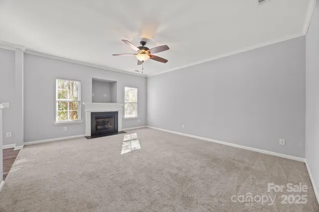 a view of empty room with fireplace and fan