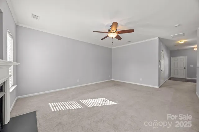 a view of a room with a ceiling fan and hardwood floor