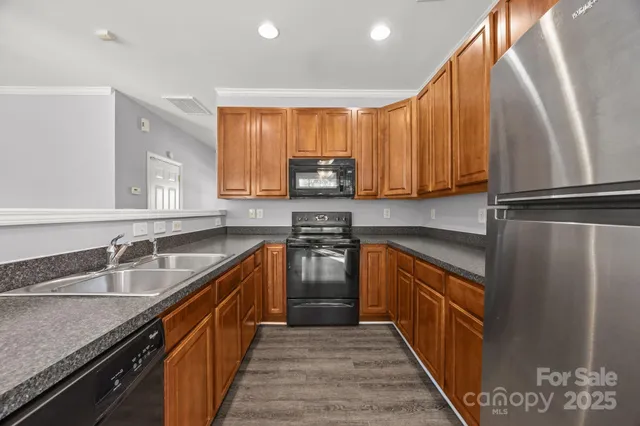 a kitchen with stainless steel appliances granite countertop a sink a stove and a refrigerator