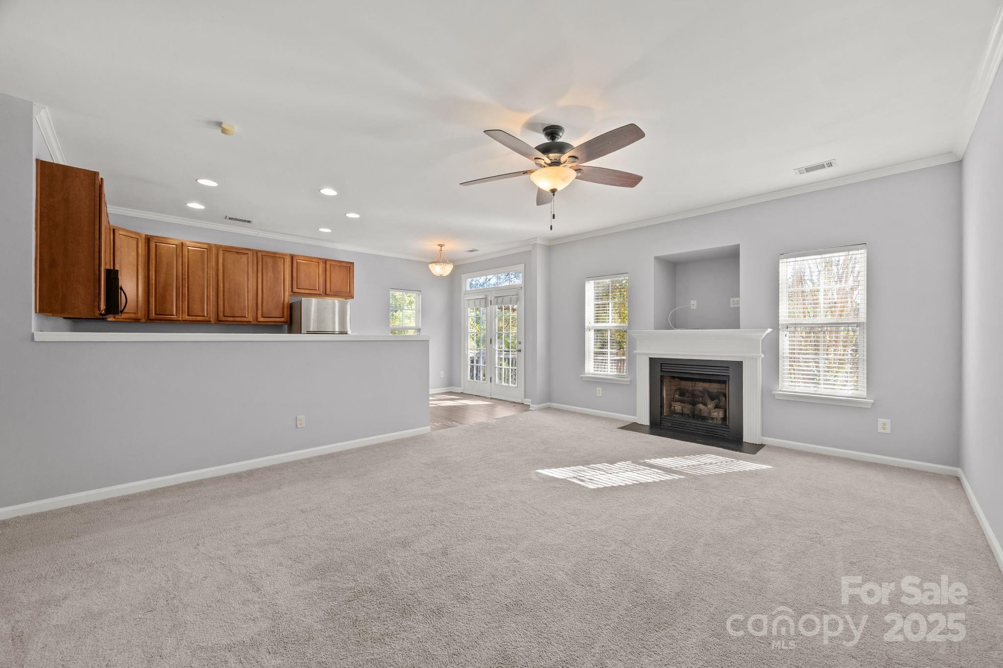 218 Tail Race Lane Fort Mill, SC 29715 - Photo 10 of 42 a view of a livingroom with a fireplace a ceiling fan and windows