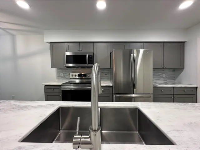 a kitchen with a refrigerator and a stove top oven
