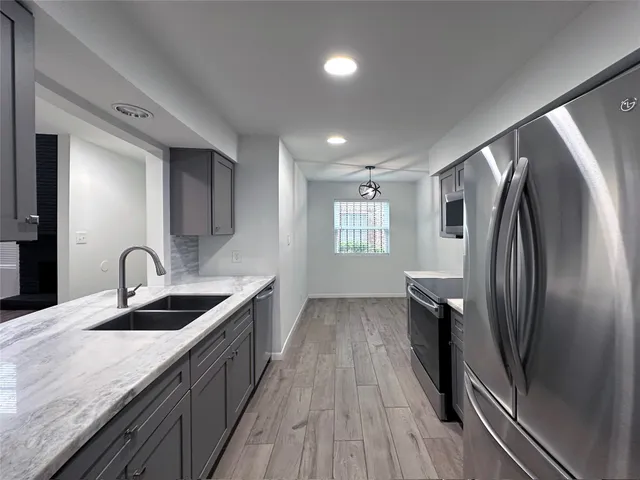 a kitchen with stainless steel appliances granite countertop a sink stove and refrigerator
