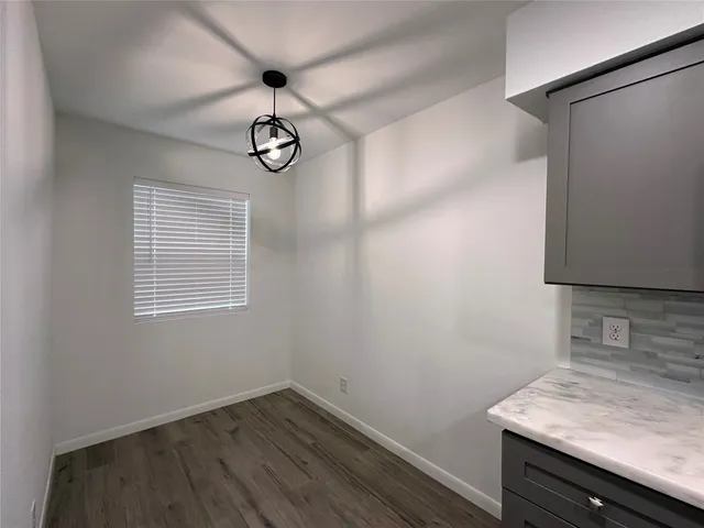 a view of a storage and utility room with wooden floor