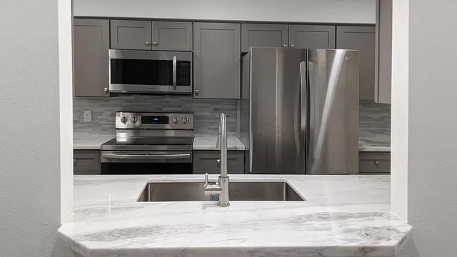 a kitchen with a refrigerator microwave and sink