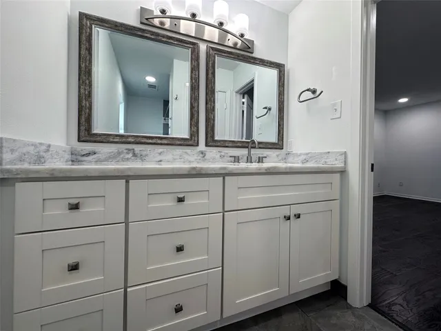 a bathroom with a sink vanity and mirror
