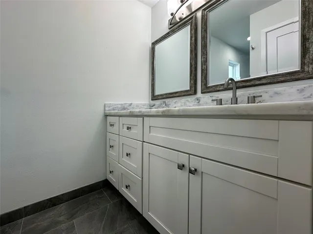 a bathroom with a granite countertop sink and a mirror