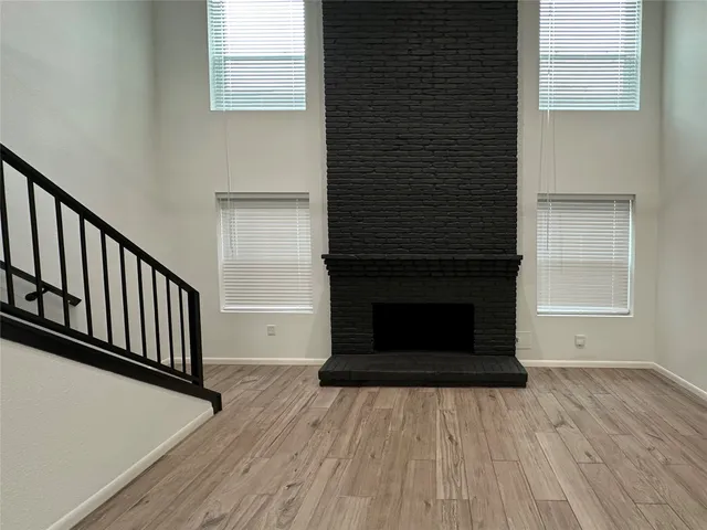 a view of a livingroom with wooden floor and staircase