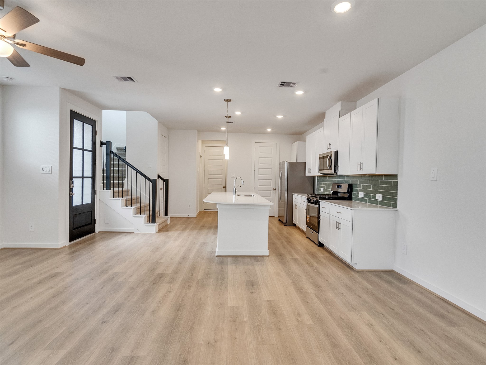 4113 Fig Grv Street Houston, TX 77080 - Photo 21 of 21 a kitchen with stainless steel appliances kitchen island hardwood floor sink stove and white cabinets