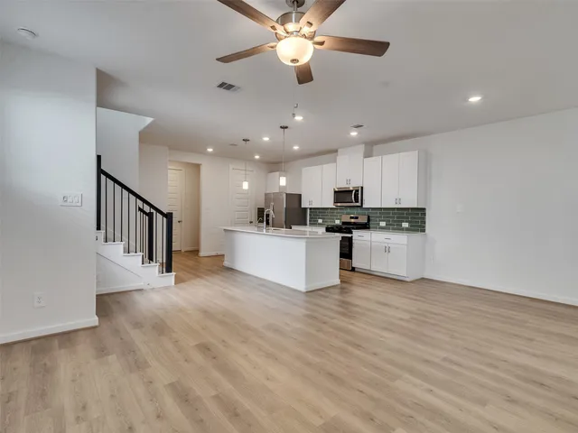 a view of a living room a kitchen and a chandelier