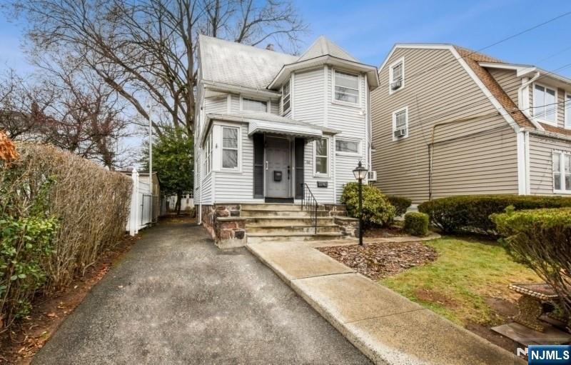 60 Berkeley Avenue Bloomfield, NJ 07003 - Photo 1 of 17 a view of a white house with large windows and a small yard