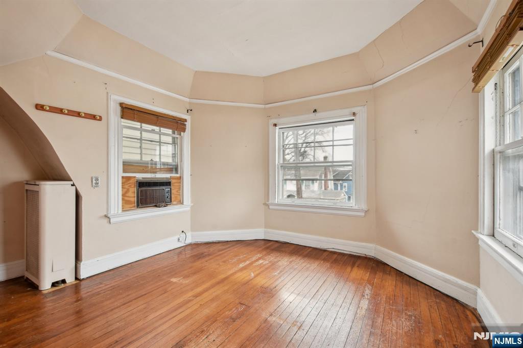 60 Berkeley Avenue Bloomfield, NJ 07003 - Photo 11 of 17 an empty room with wooden floor and windows