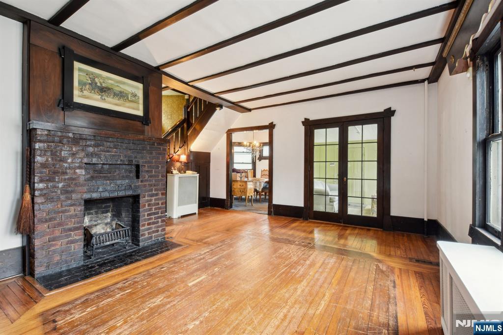60 Berkeley Avenue Bloomfield, NJ 07003 - Photo 3 of 17 a view of an empty room with wooden floor fireplace and a window