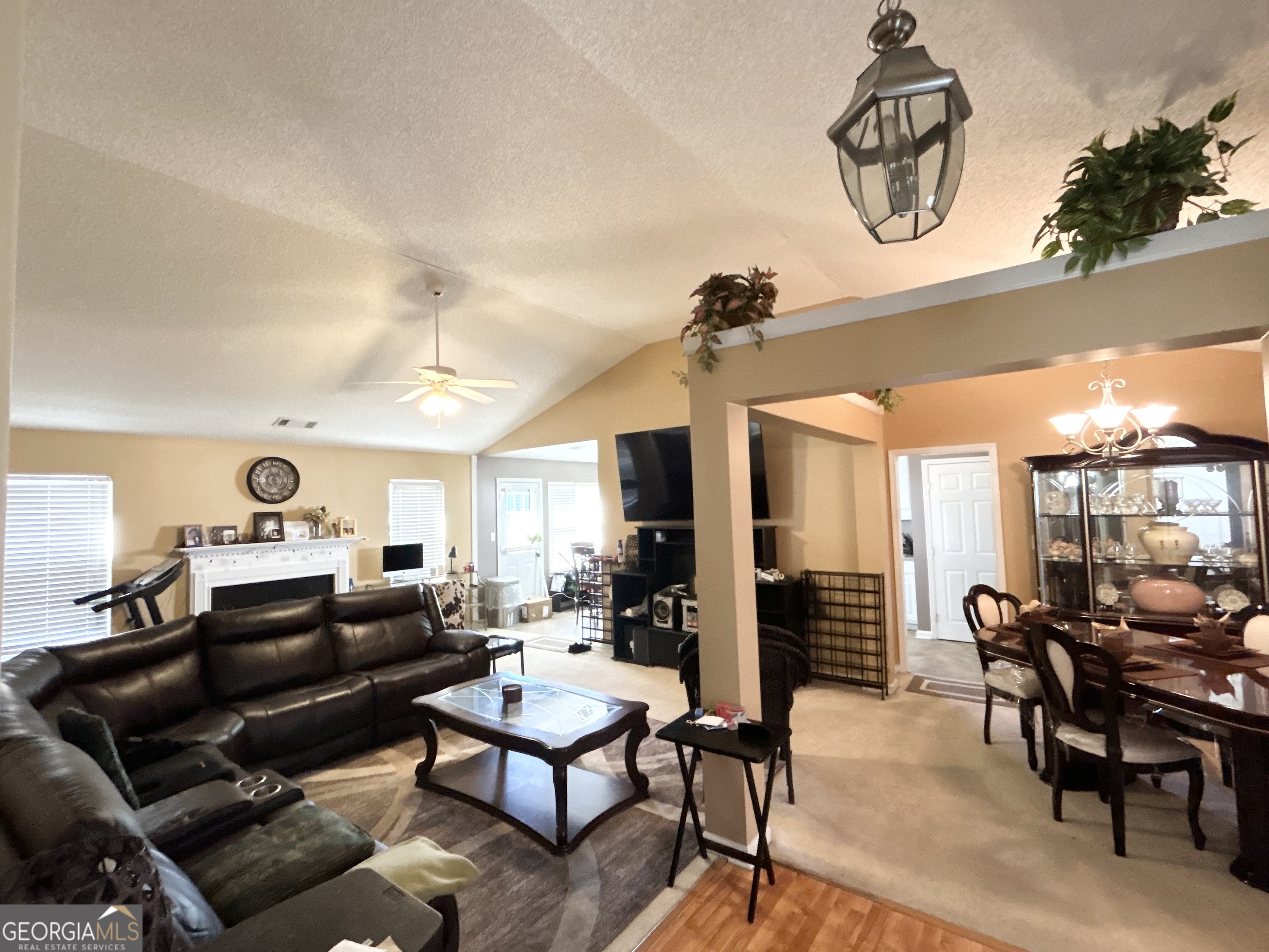 4889 Ozment Ridge Court Lithonia, GA 30038 - Photo 7 of 16 a living room with furniture a rug and a chandelier