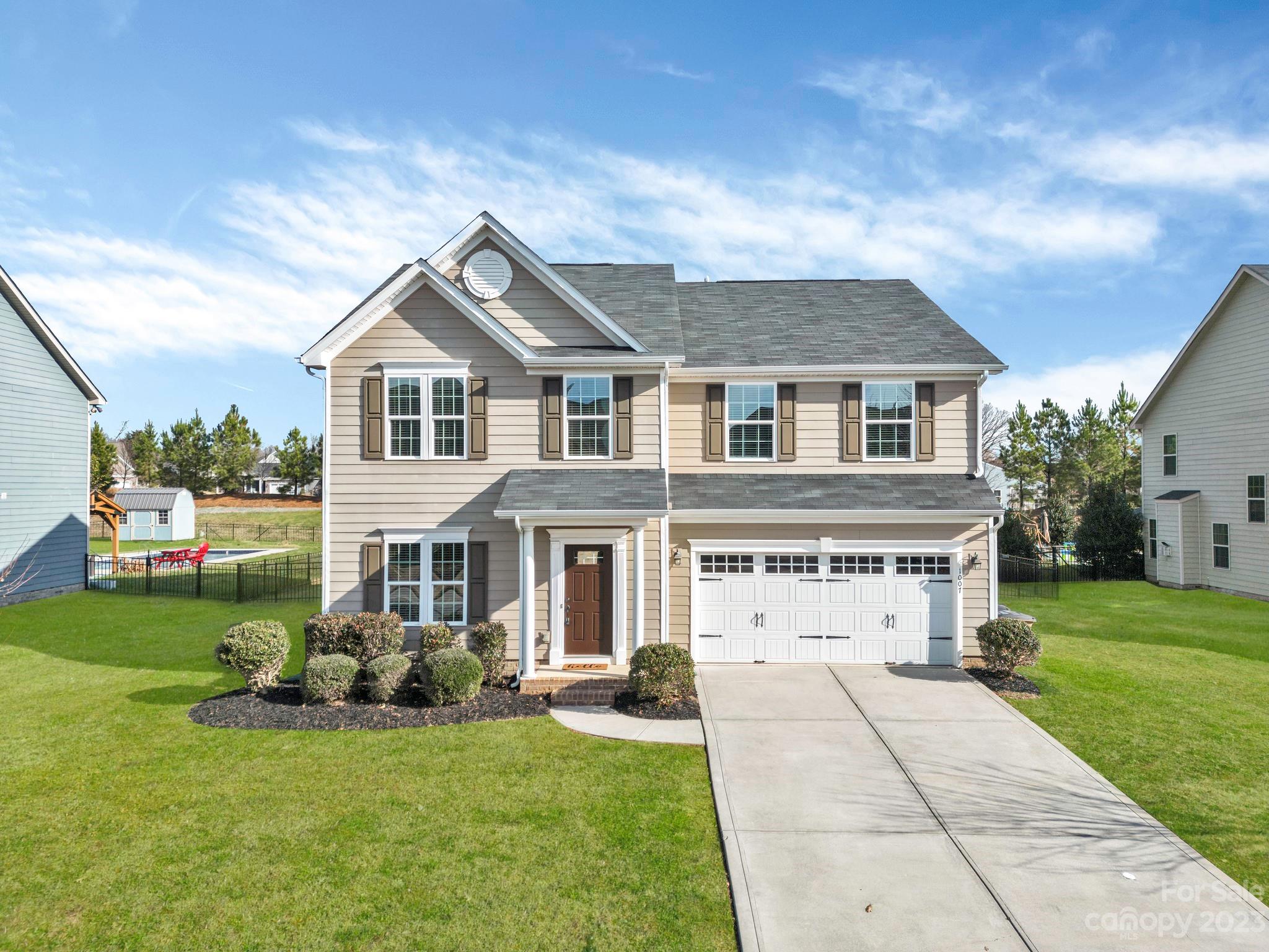 a front view of a house with a yard and garage