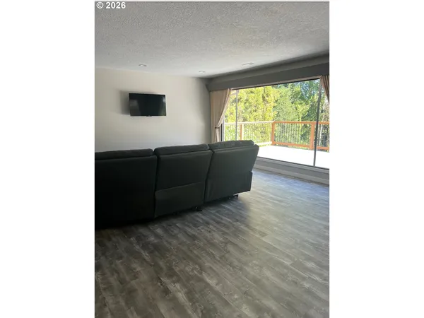 a living room with wooden floor and large window