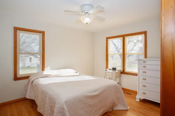 a bedroom with a bed and a dresser next to a window