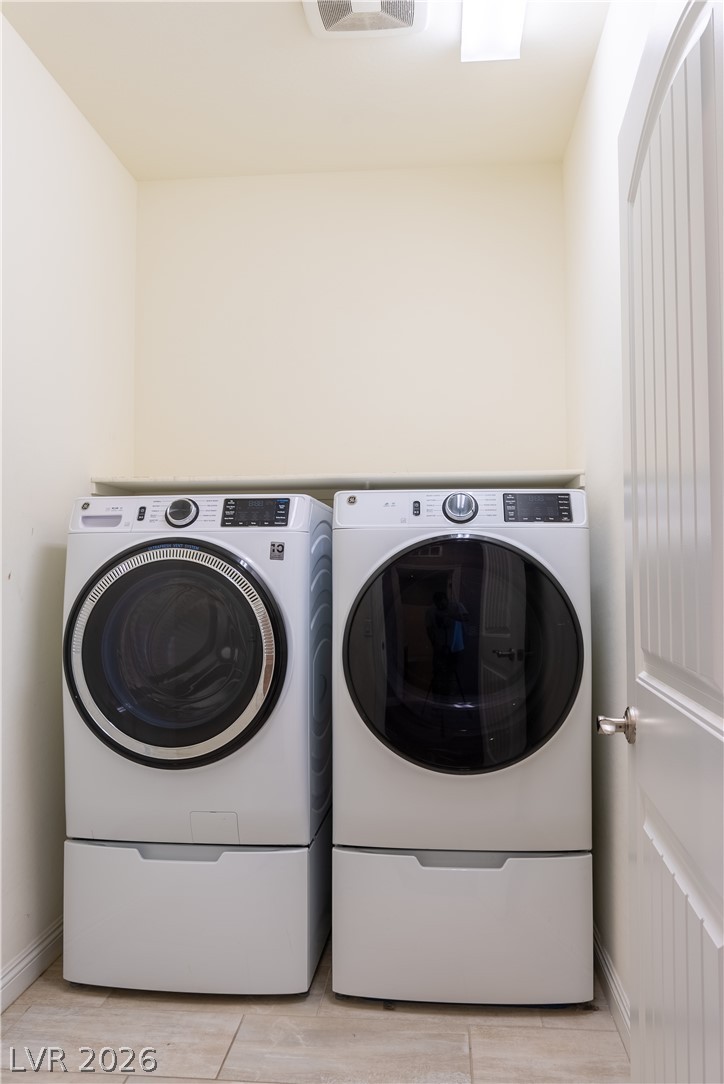 11045 Elk Sands Road Las Vegas, NV 89179 - Photo 23 of 67 Functional laundry nook features overhead storage shelving and durable tile flooring.