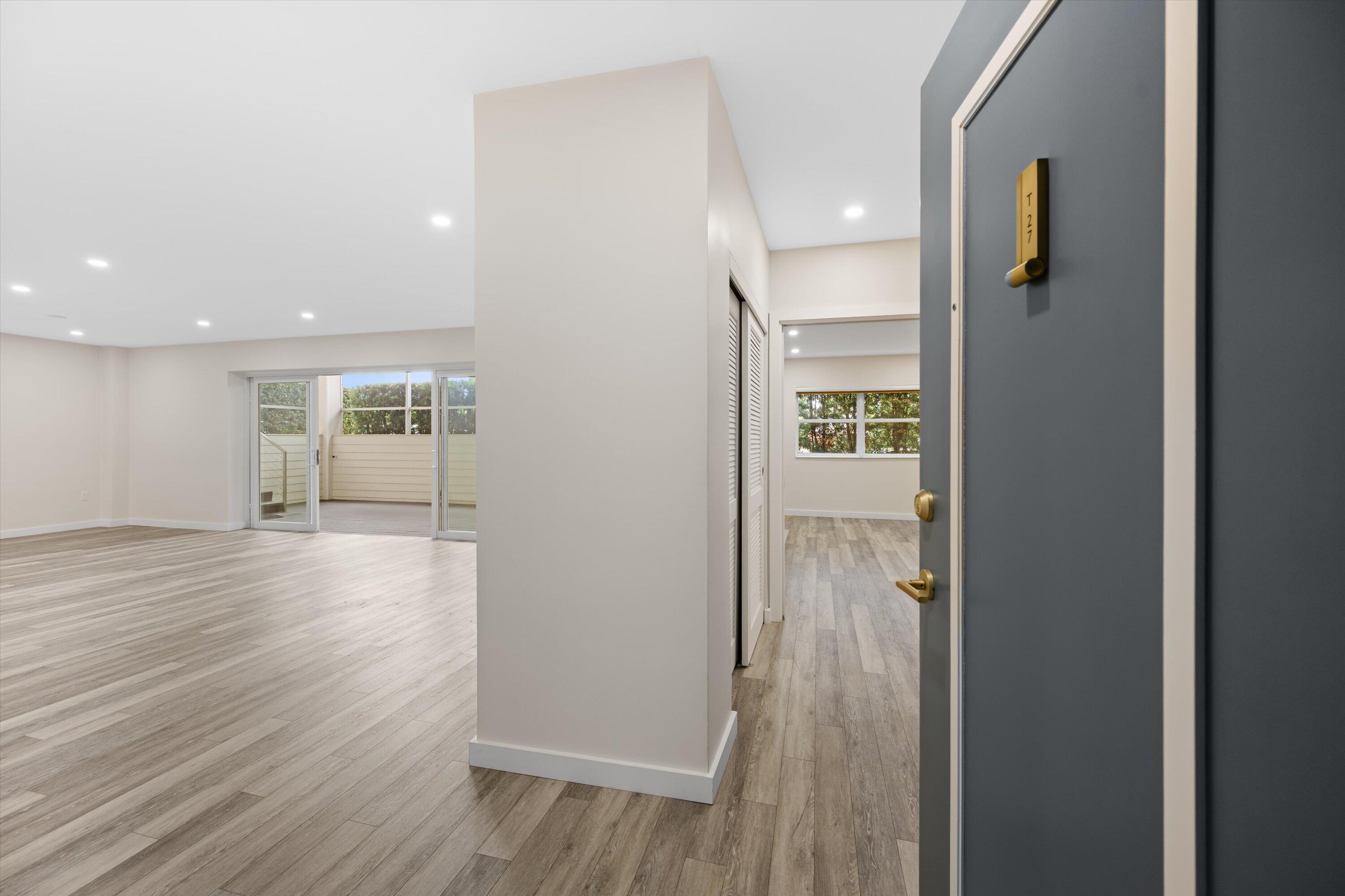 a view of a hallway with wooden floor