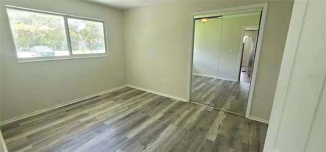 a view of a small space with wooden floor and a window