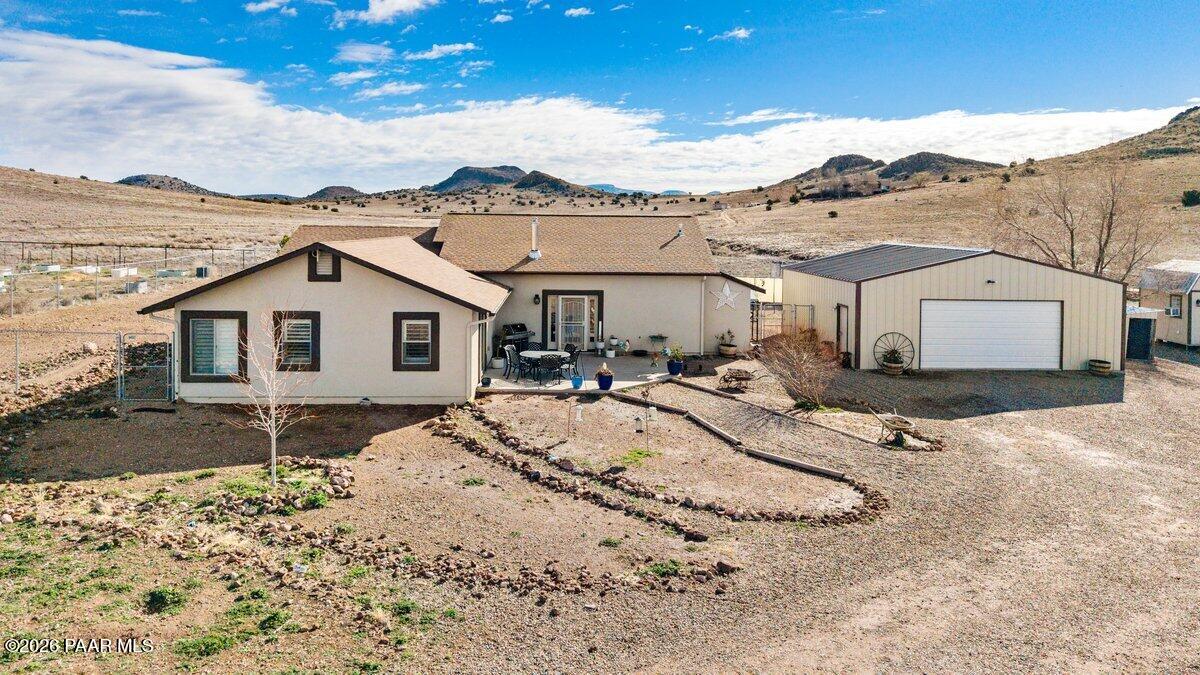 a view of a white house next to a yard and mountain