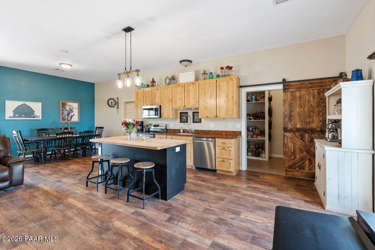 5757 East Longhorn Road Chino Valley, AZ 86323 - Photo 3 of 34 a kitchen with stainless steel appliances a dining table chairs stove and refrigerator