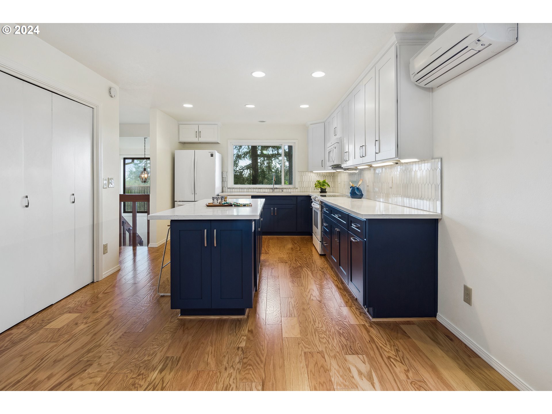 4243 Southwest Stephenson Street Portland, OR 97219 - Photo 15 of 48 a kitchen with kitchen island granite countertop a sink cabinets and wooden floor