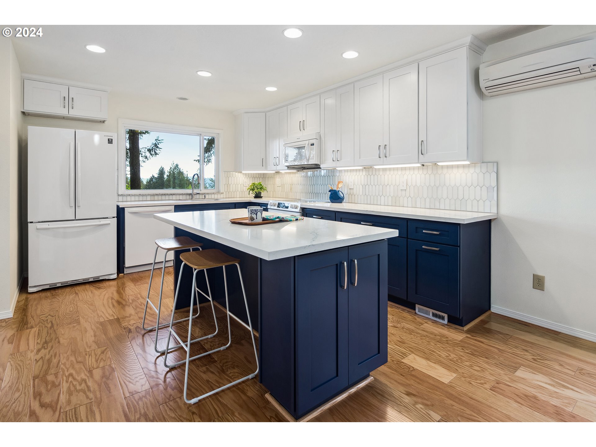 4243 Southwest Stephenson Street Portland, OR 97219 - Photo 16 of 48 a kitchen with a table chairs refrigerator and microwave