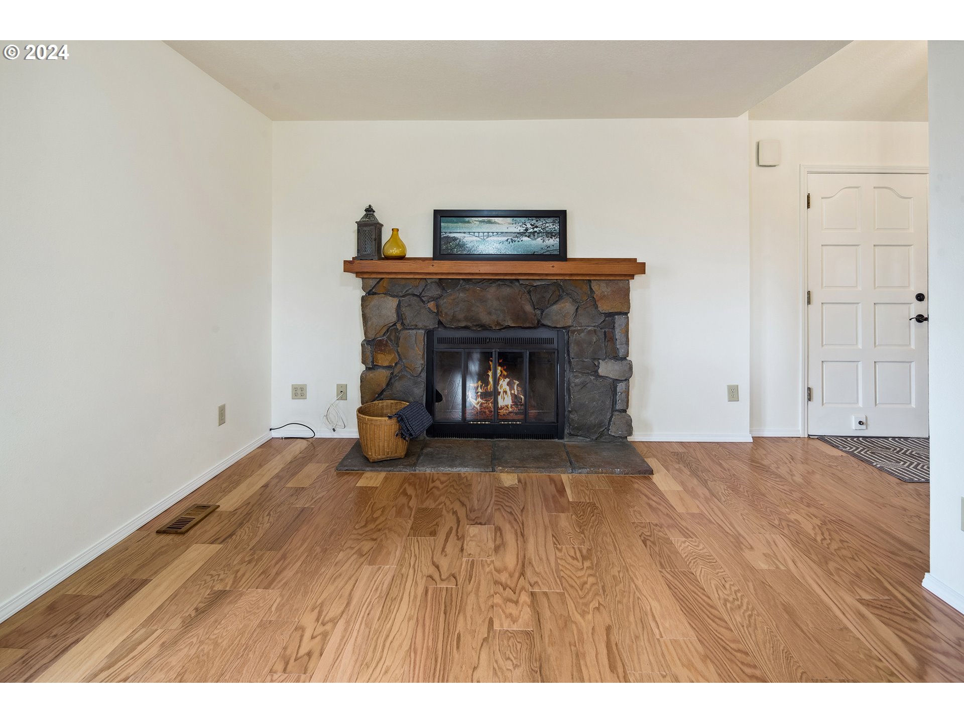 4243 Southwest Stephenson Street Portland, OR 97219 - Photo 22 of 48 a view of an empty room with wooden floor and a fireplace