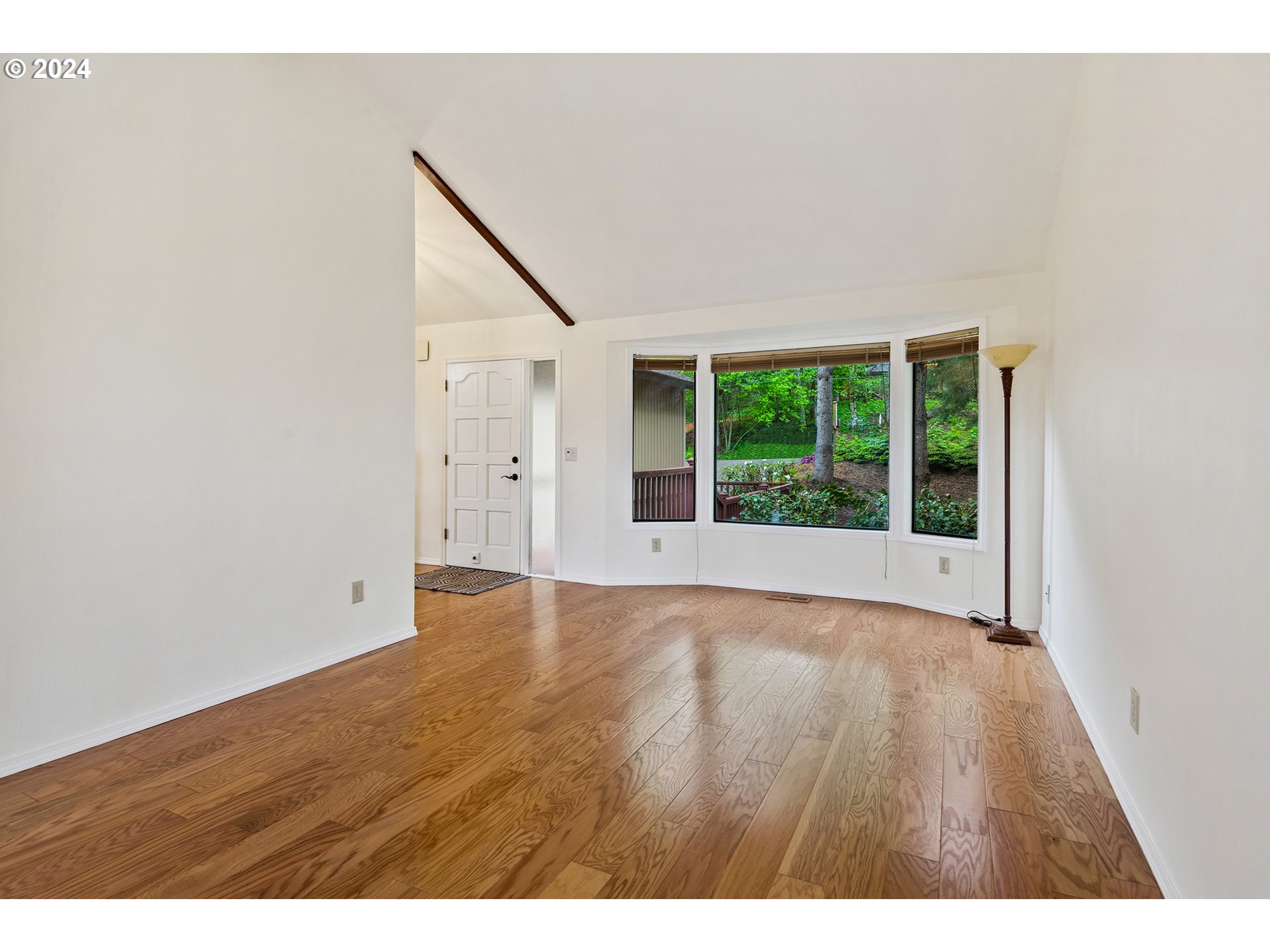 4243 Southwest Stephenson Street Portland, OR 97219 - Photo 6 of 48 a view of an empty room with wooden floor and a window