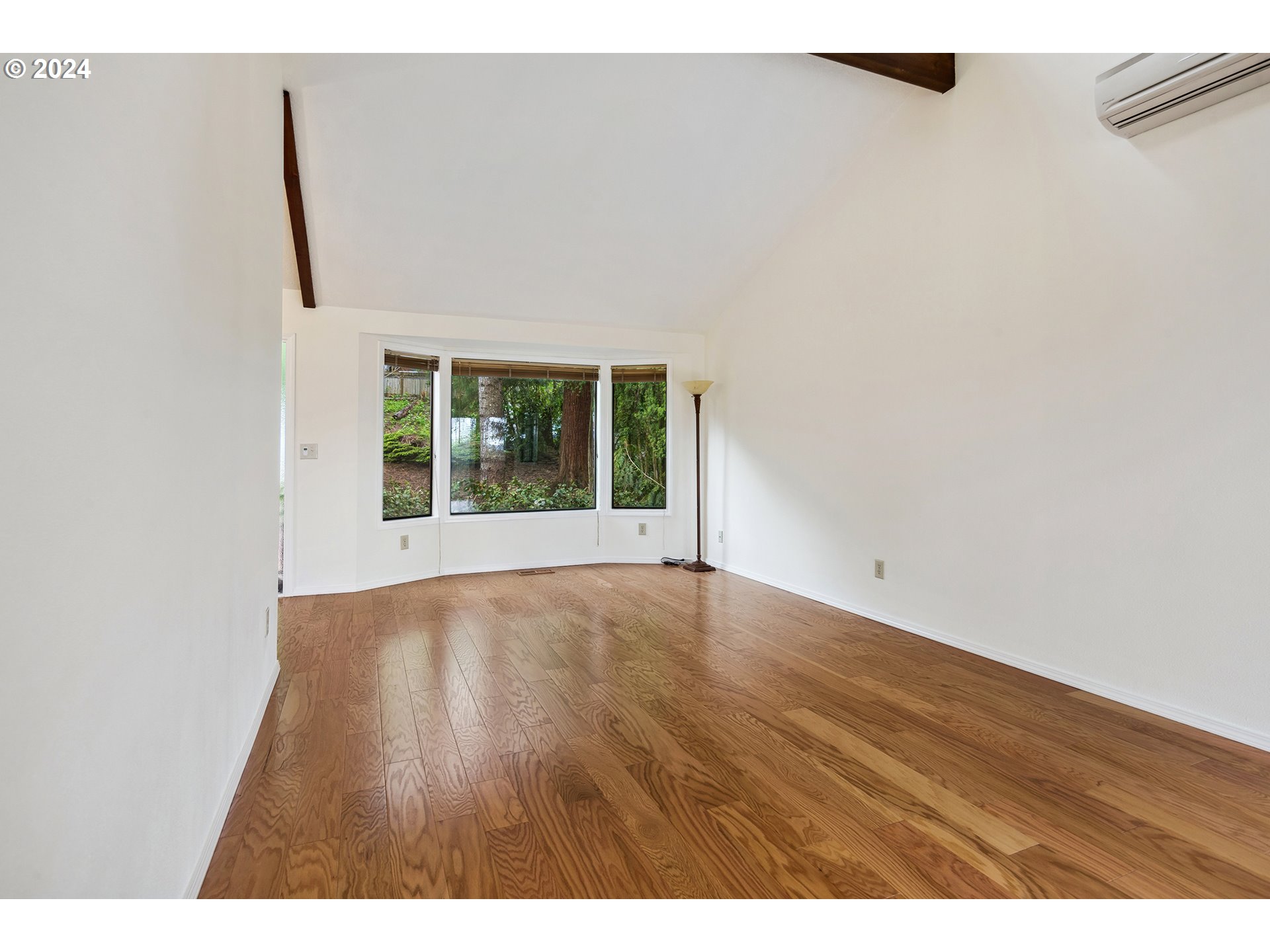 4243 Southwest Stephenson Street Portland, OR 97219 - Photo 7 of 48 a view of an empty room with wooden floor and windows