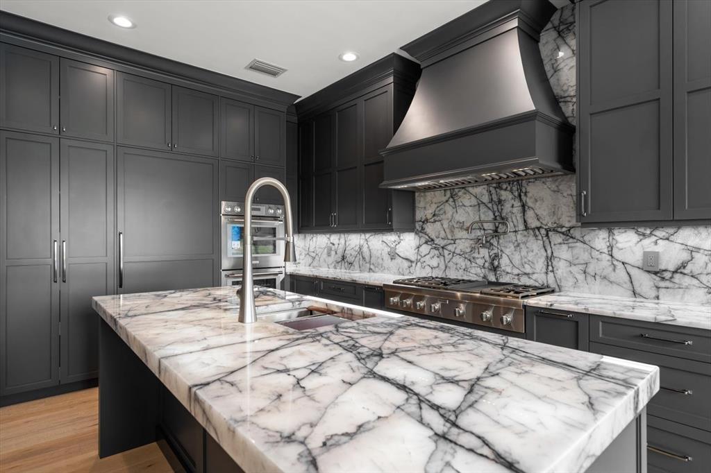 19 Hibiscus Road Belleair, FL 33756 - Photo 19 of 44 a kitchen with granite countertop a sink a stove and cabinets